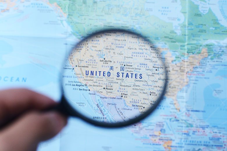 hand over united states map with magnifying glass to signify areas of interest for shepherd royalty mineral acquisition specialists